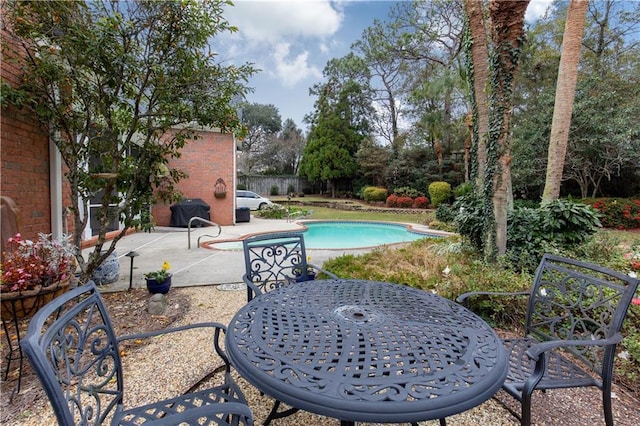 view of pool with outdoor dining area, a patio, and a fenced in pool