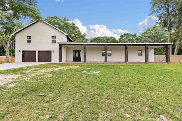 view of front of house with a front yard, fence, a garage, and driveway