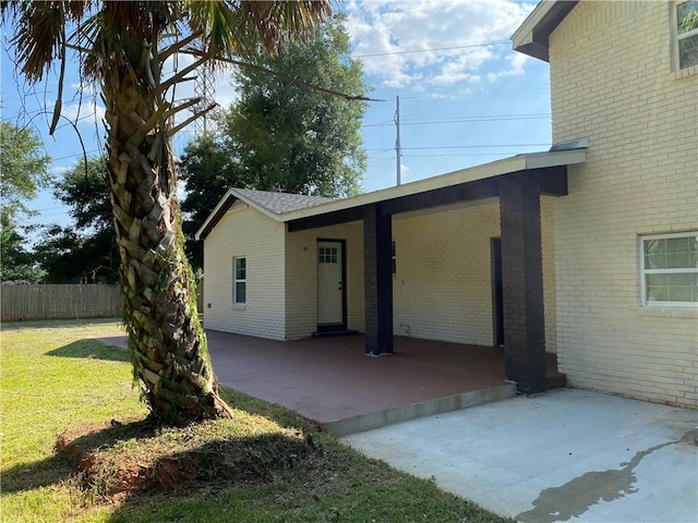 back of house featuring a patio area and a lawn