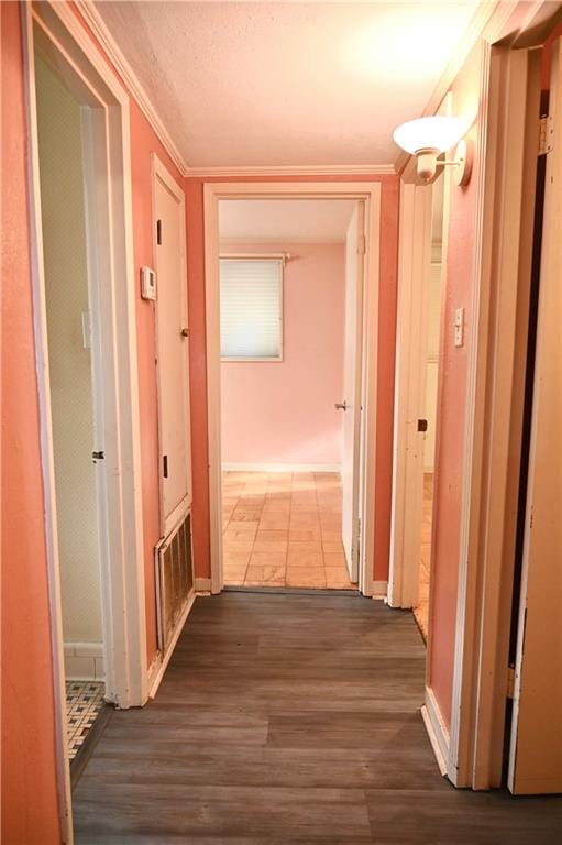 hallway featuring hardwood / wood-style floors and crown molding