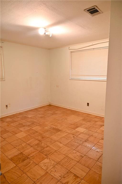 unfurnished room featuring a textured ceiling