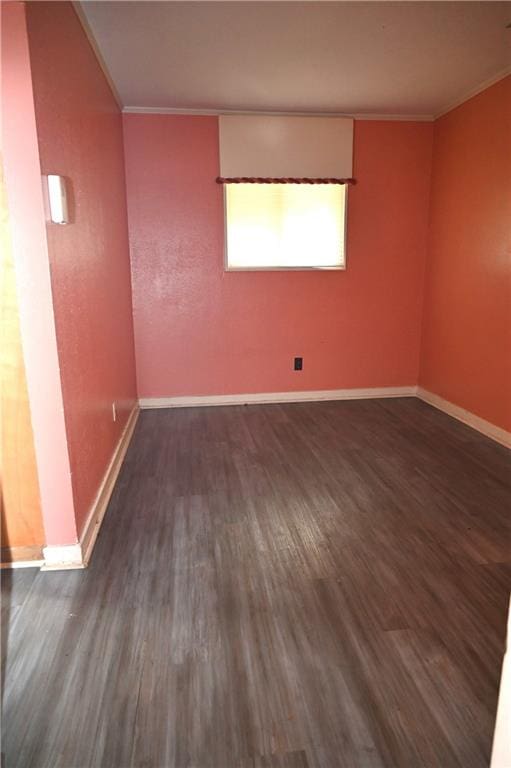 empty room featuring ornamental molding and dark hardwood / wood-style flooring