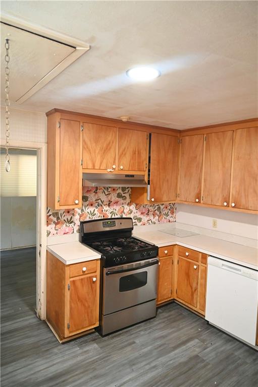 kitchen featuring backsplash, white dishwasher, stainless steel range with gas stovetop, and dark hardwood / wood-style flooring