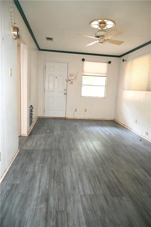 interior space with ornamental molding, dark hardwood / wood-style floors, and ceiling fan