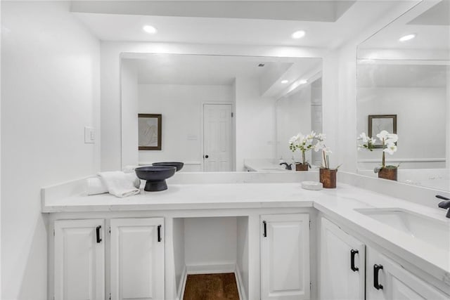 full bathroom with double vanity, recessed lighting, and a sink