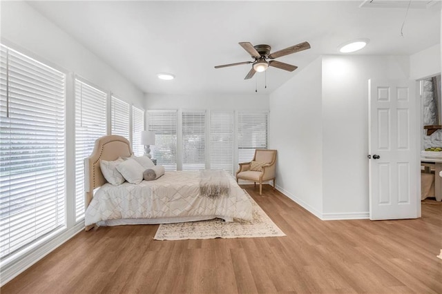 bedroom featuring ceiling fan, baseboards, attic access, and light wood-style flooring