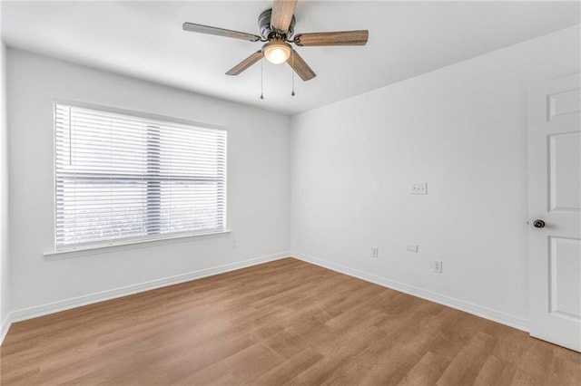 empty room with light wood-style floors, a ceiling fan, and baseboards