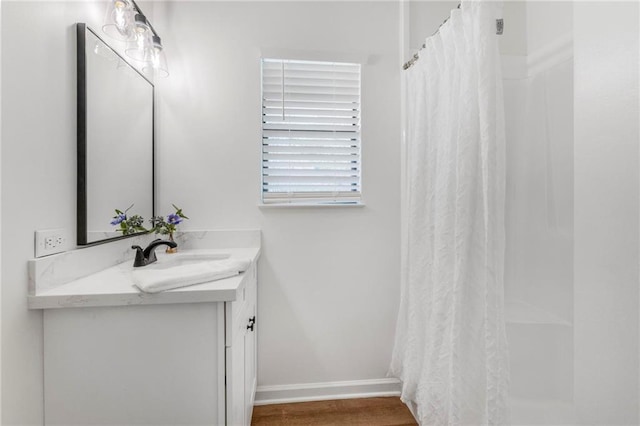 bathroom with a shower with curtain, vanity, baseboards, and wood finished floors