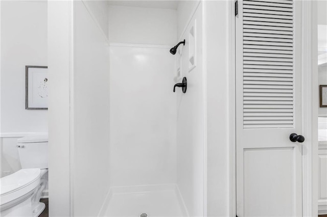 full bathroom with a shower stall and toilet