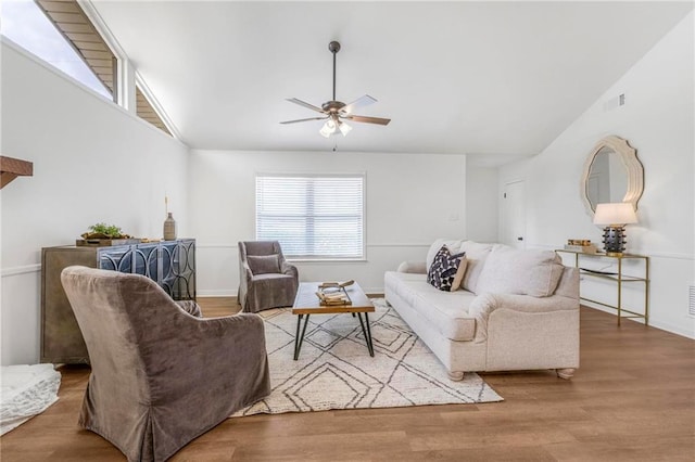 living area with ceiling fan, visible vents, lofted ceiling, and wood finished floors