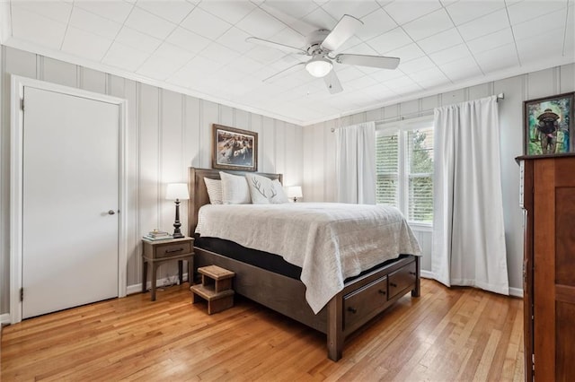 bedroom with crown molding, light hardwood / wood-style floors, and ceiling fan