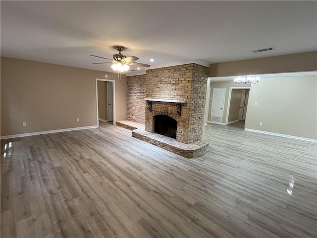 unfurnished living room with hardwood / wood-style floors, ceiling fan, and a fireplace