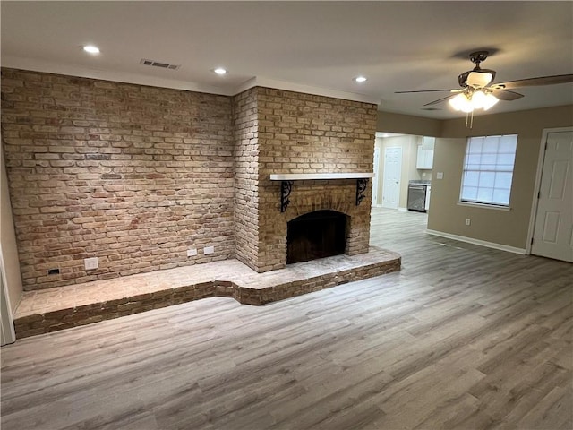 unfurnished living room with ornamental molding, hardwood / wood-style floors, ceiling fan, and a brick fireplace