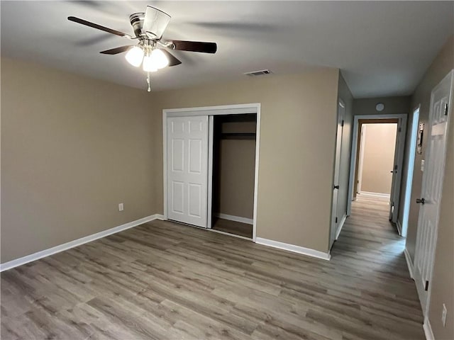 unfurnished bedroom featuring light hardwood / wood-style flooring, a closet, and ceiling fan