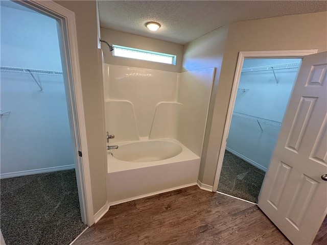 bathroom featuring shower / tub combination, wood-type flooring, and a textured ceiling