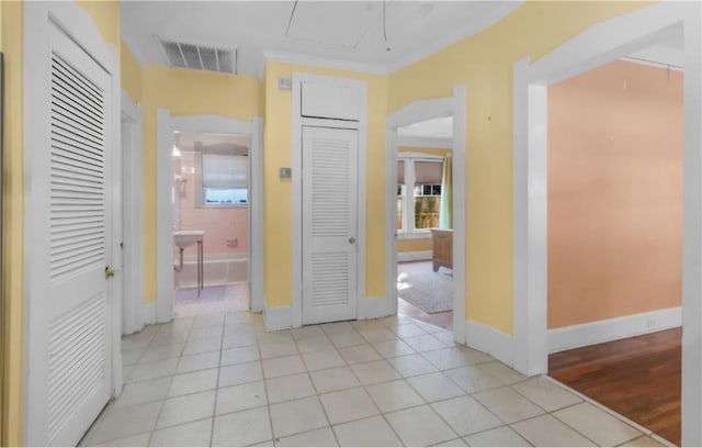 interior space featuring light tile patterned floors and crown molding