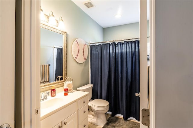 bathroom featuring walk in shower, vanity, and toilet