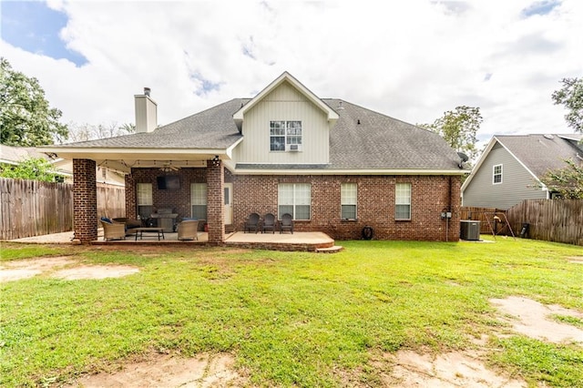 rear view of property featuring a patio, central air condition unit, and a yard