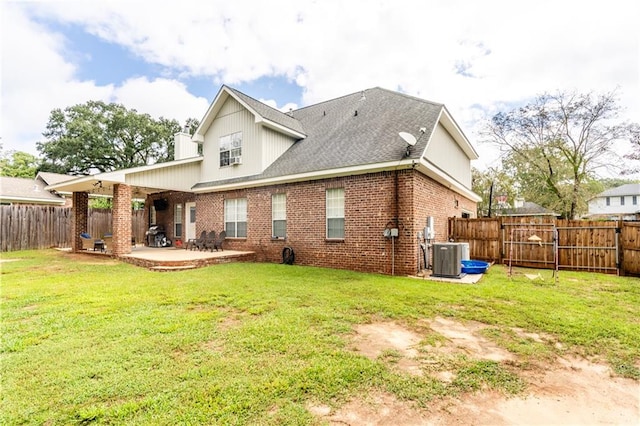 rear view of property featuring cooling unit, a yard, and a patio