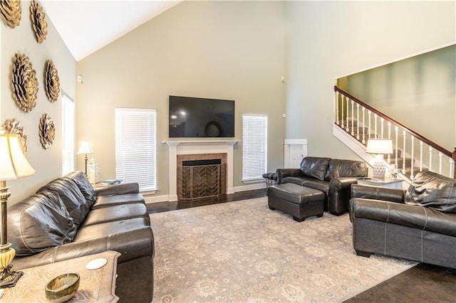 living room featuring high vaulted ceiling and a tile fireplace