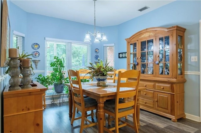 dining room with a chandelier and dark wood-type flooring