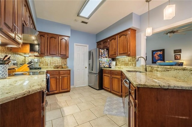 kitchen with decorative backsplash, stainless steel appliances, sink, pendant lighting, and ceiling fan