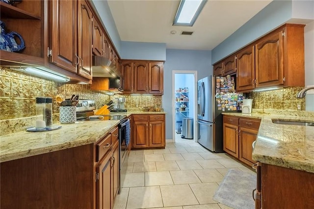 kitchen with light stone countertops, sink, stainless steel appliances, decorative backsplash, and light tile patterned floors