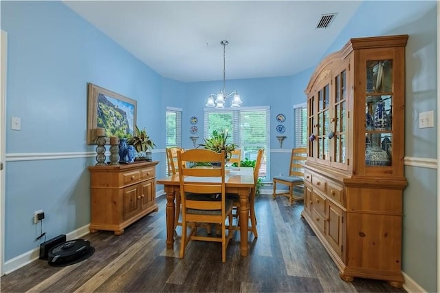 dining room featuring dark hardwood / wood-style floors and a chandelier