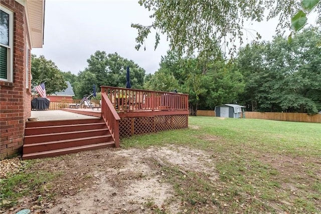 view of yard featuring a wooden deck and a storage unit