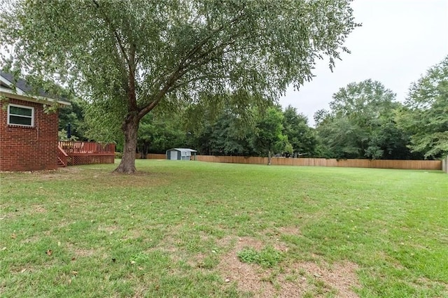 view of yard with a wooden deck and a storage unit