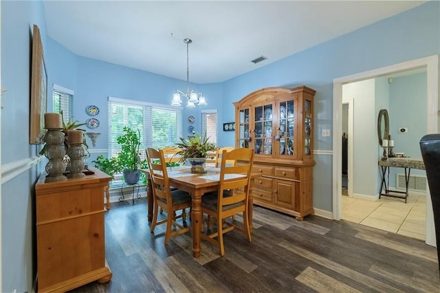 dining space with wood-type flooring and an inviting chandelier