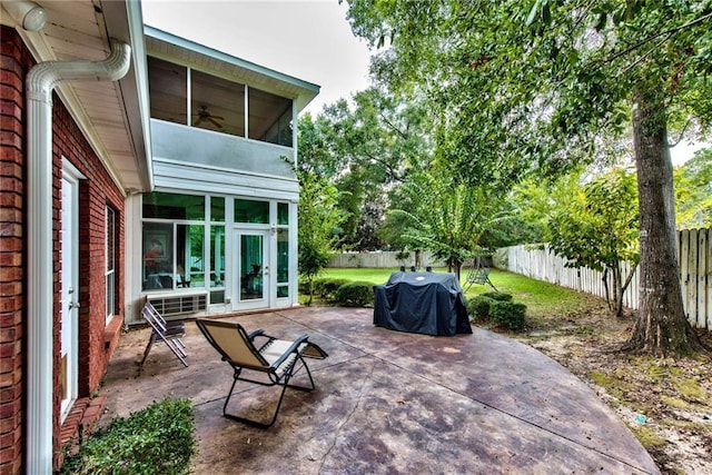 view of patio featuring a sunroom, grilling area, and french doors