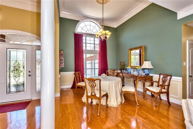 dining room featuring hardwood / wood-style floors, decorative columns, and ornamental molding