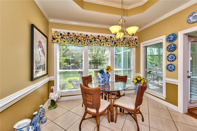 tiled dining space with a raised ceiling, plenty of natural light, and ornamental molding