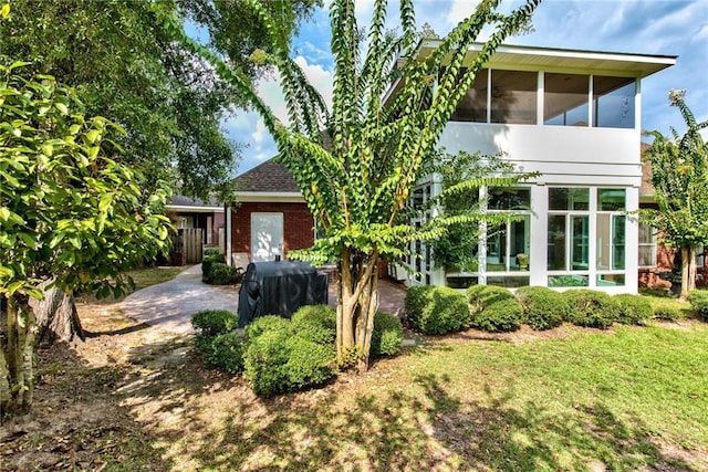 view of front facade featuring a sunroom and a front yard