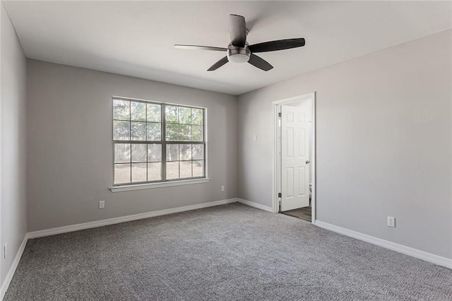 empty room with dark carpet and ceiling fan