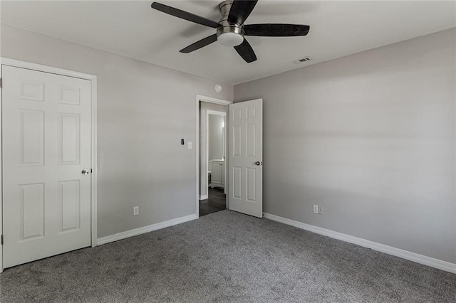 unfurnished bedroom featuring dark carpet and ceiling fan