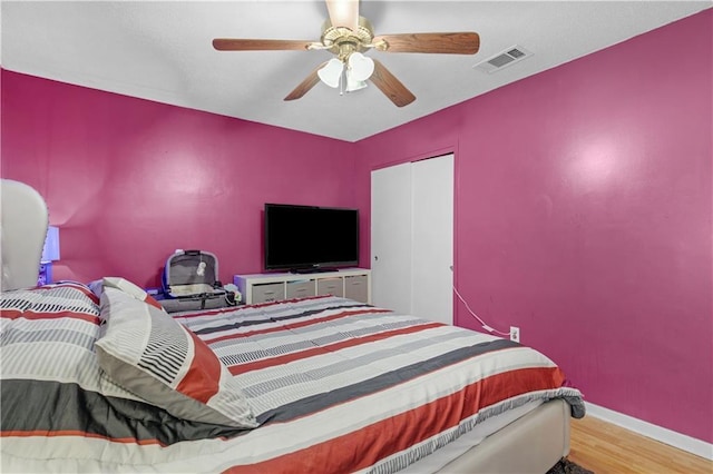 bedroom with ceiling fan and wood-type flooring