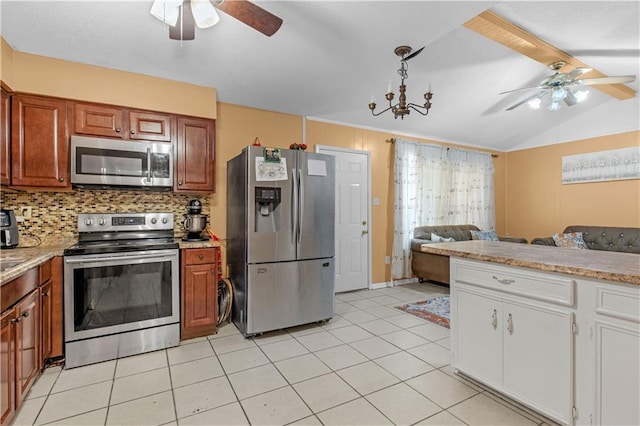 kitchen featuring ceiling fan with notable chandelier, appliances with stainless steel finishes, backsplash, and lofted ceiling