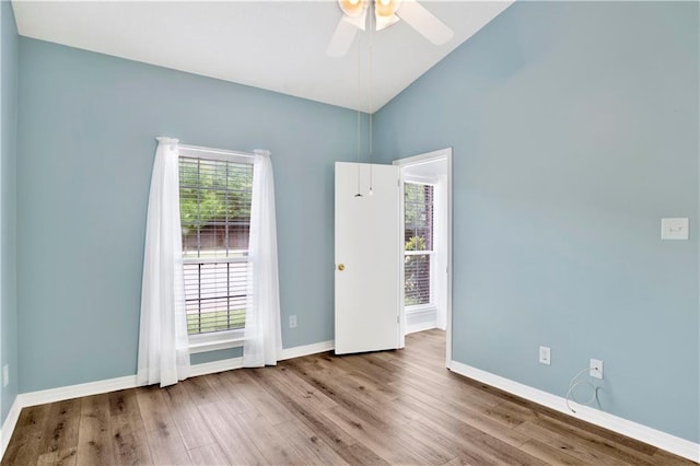 empty room featuring baseboards, ceiling fan, wood finished floors, and high vaulted ceiling