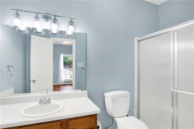 full bathroom with vanity, a stall shower, and toilet