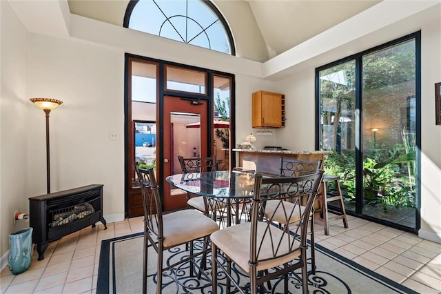 tiled dining space with a wood stove and high vaulted ceiling