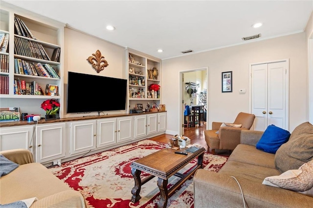 living room featuring ornamental molding, light wood-type flooring, and built in shelves