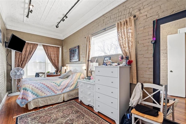 51 Jackson St N Unit A, Mobile, AL 36602 - bedroom featuring rail lighting, wood-type flooring, multiple windows, ornamental molding, and brick wall