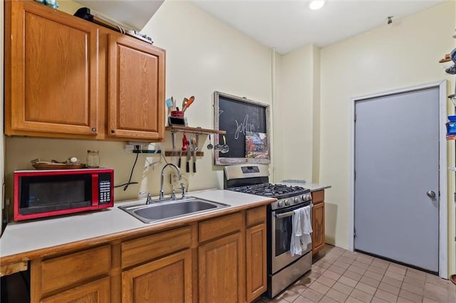 51 Jackson St N Unit A, Mobile, AL 36602 - kitchen with gas range, light countertops, light tile patterned flooring, and brown cabinetry