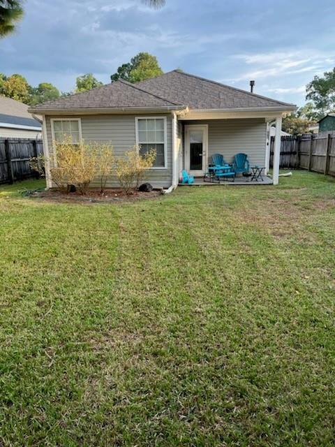 rear view of house featuring a patio area and a yard