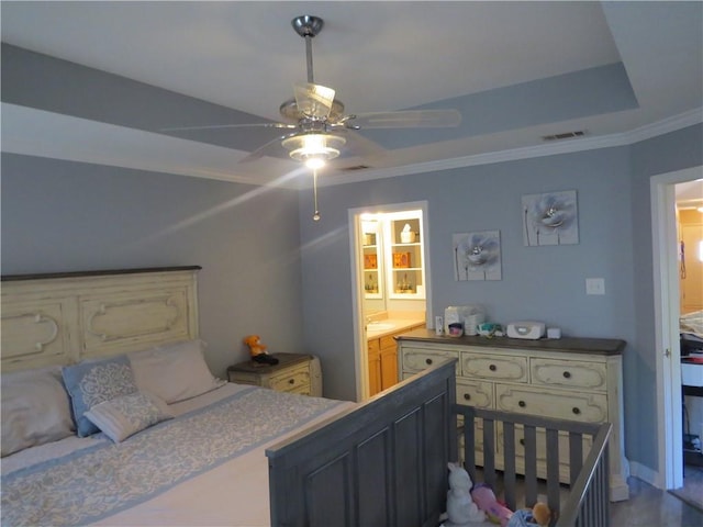 bedroom featuring ceiling fan, crown molding, and ensuite bathroom