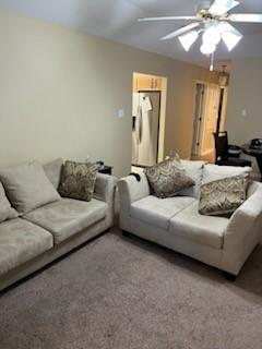 living room with ceiling fan and carpet flooring