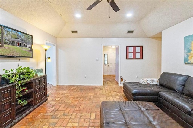 living room with ceiling fan, a textured ceiling, and vaulted ceiling