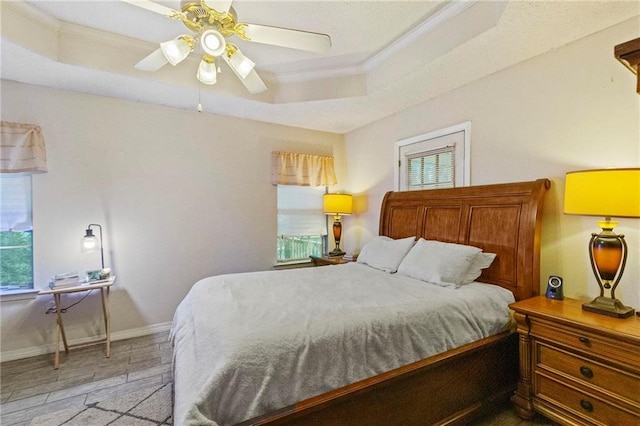 bedroom featuring a raised ceiling, ceiling fan, crown molding, and light wood-type flooring